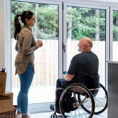 man in wheelchair talking with woman